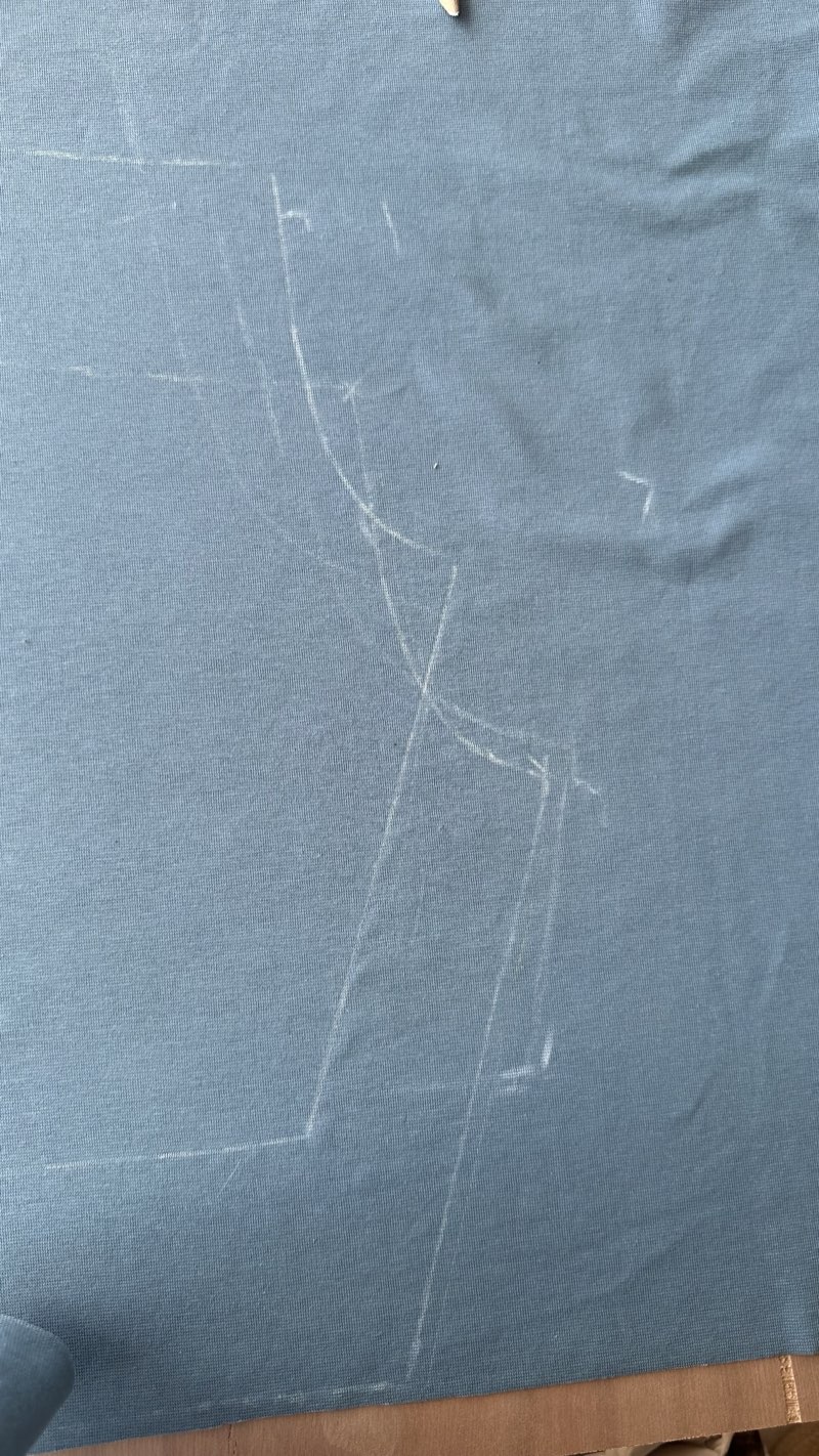 Shorts pattern drawn in white chalk on blue cotton jersey
