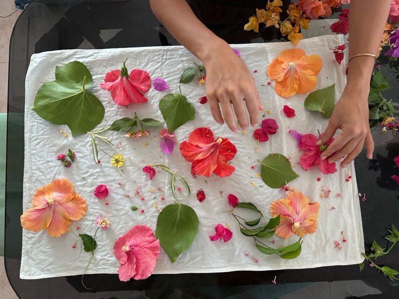 Hands arranging flowers and leaves on the silk